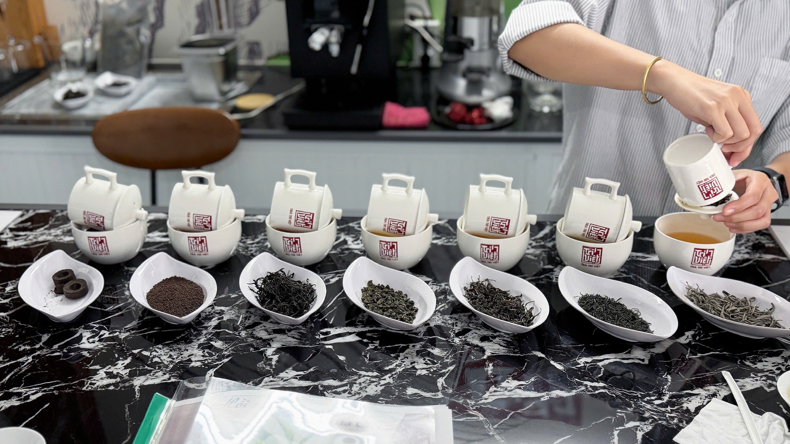 Các mẫu lá khô và nước trà được chuẩn bị để đối chiếu trong phần cupping.